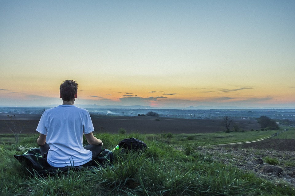 man meditating in the field for best beginner bass guitar
