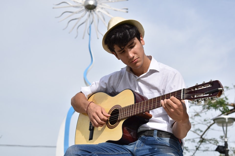 man playing his guitar alone where he could concentrate better