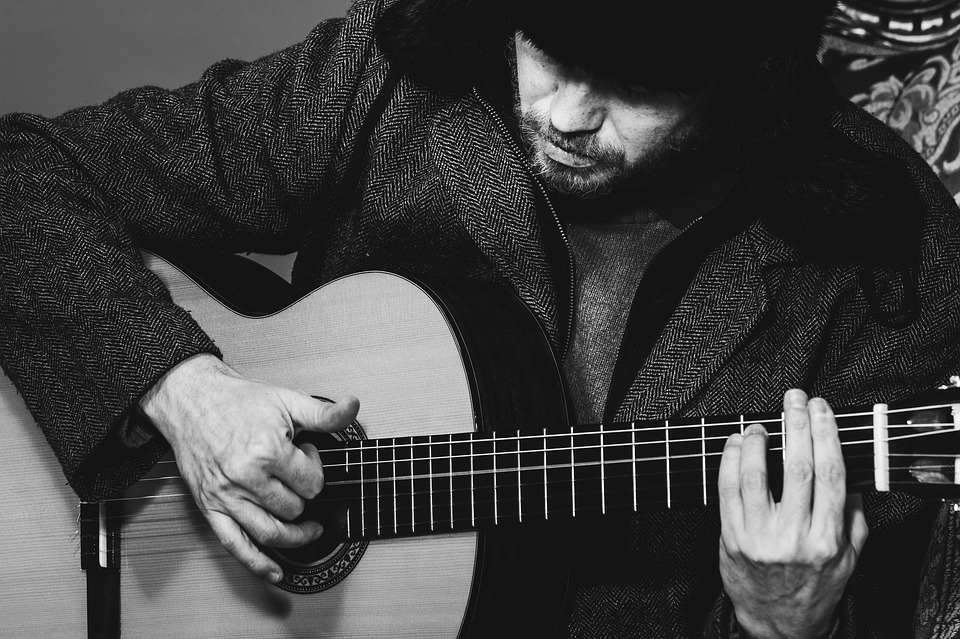 man playing music using his guitar to improve memory