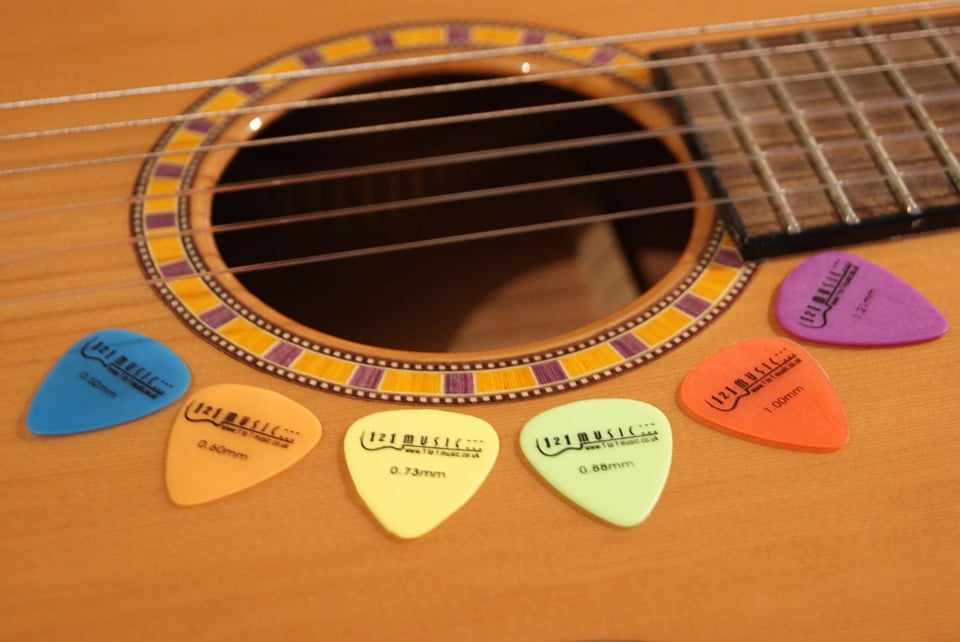 different colors of flat picks on the guitar