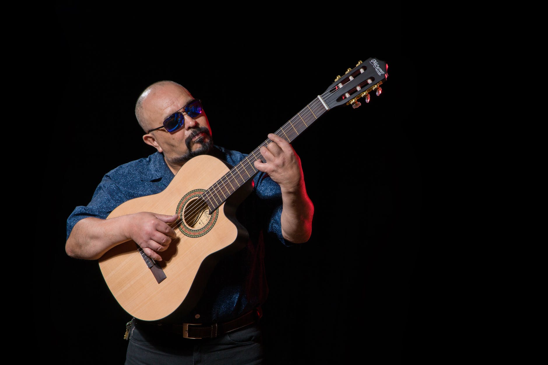 man playing the guitar using picking