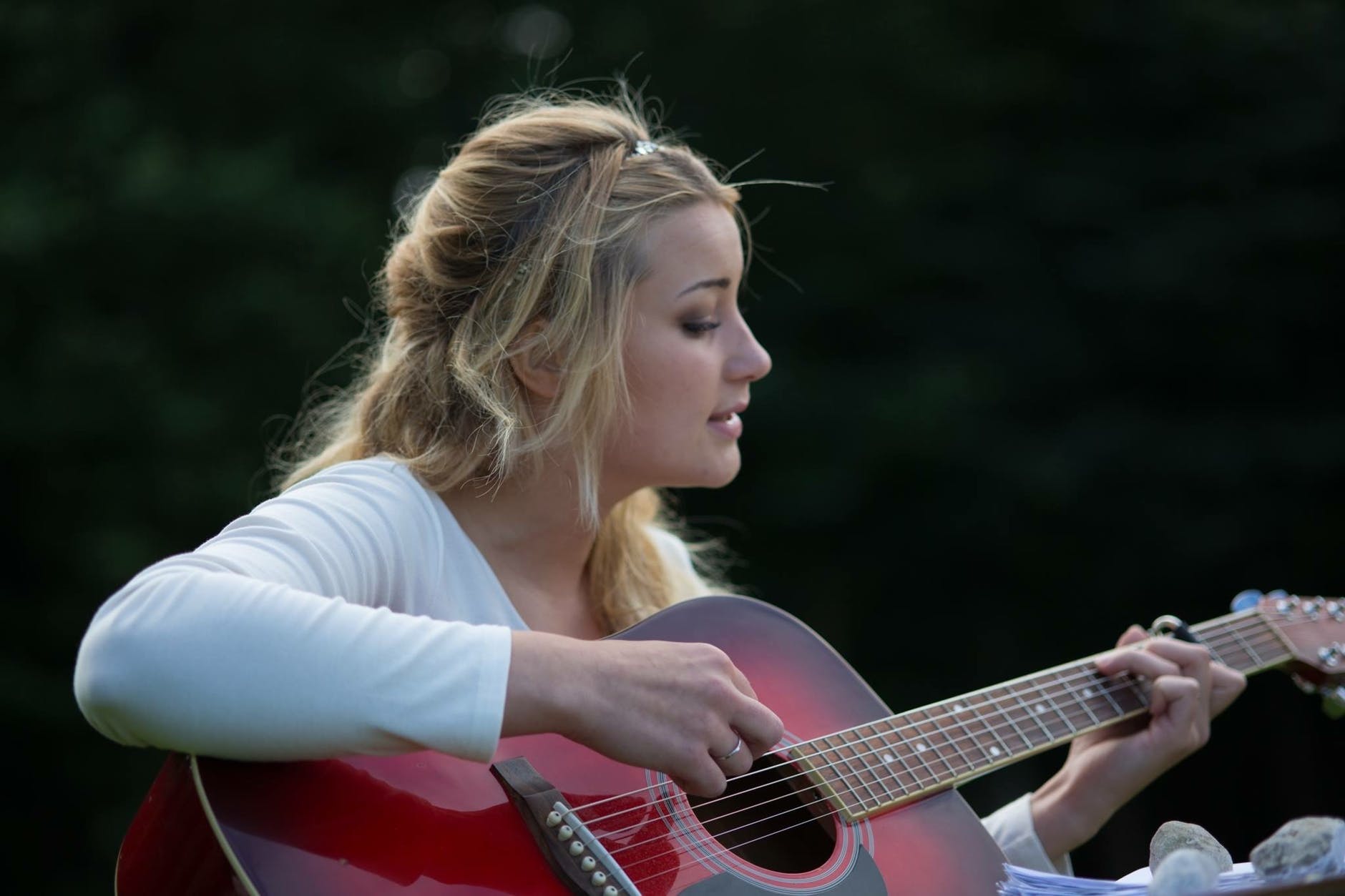 Woman singing while playing the guitar