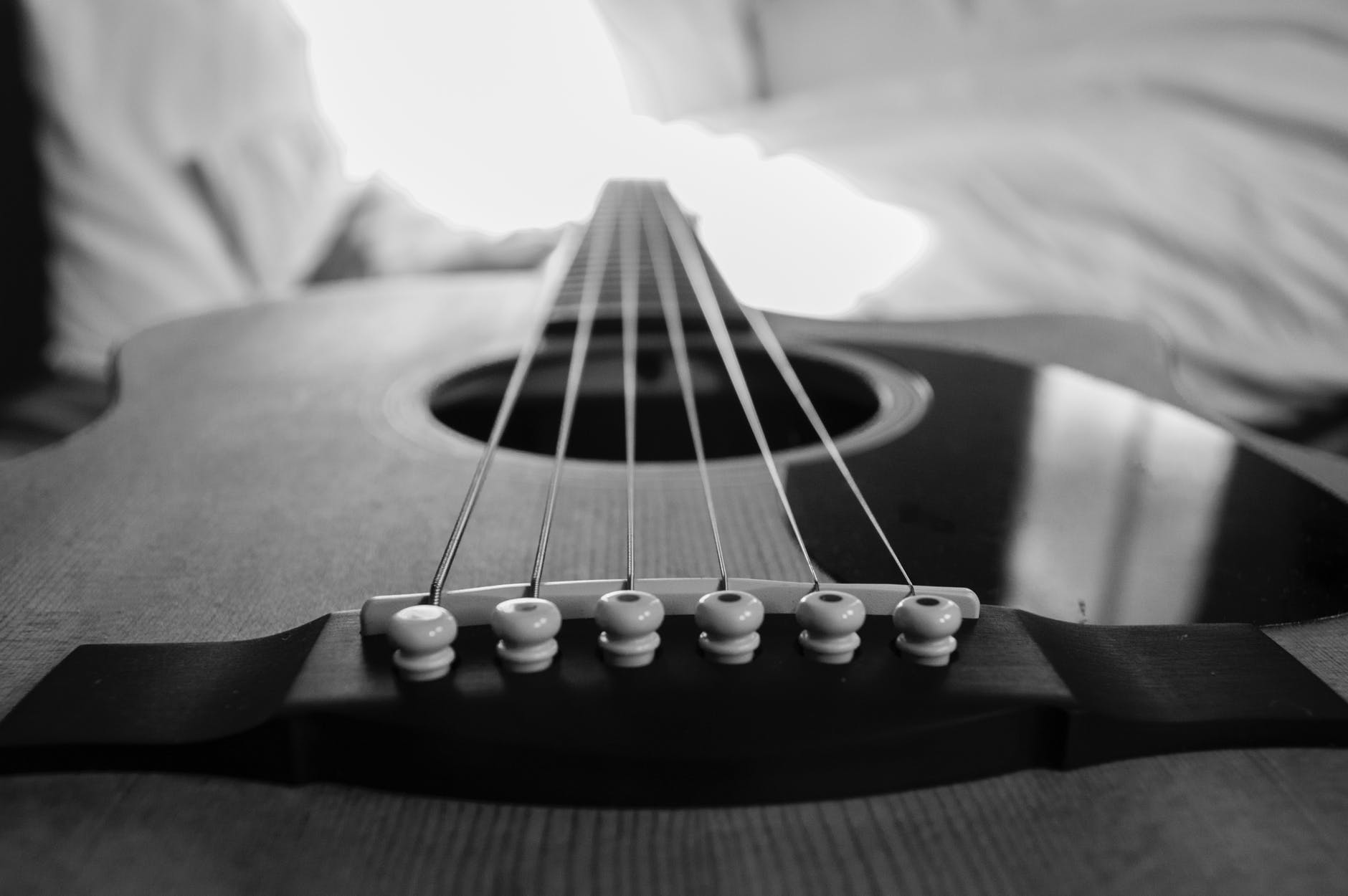 saddle holding up the strings of the guitar