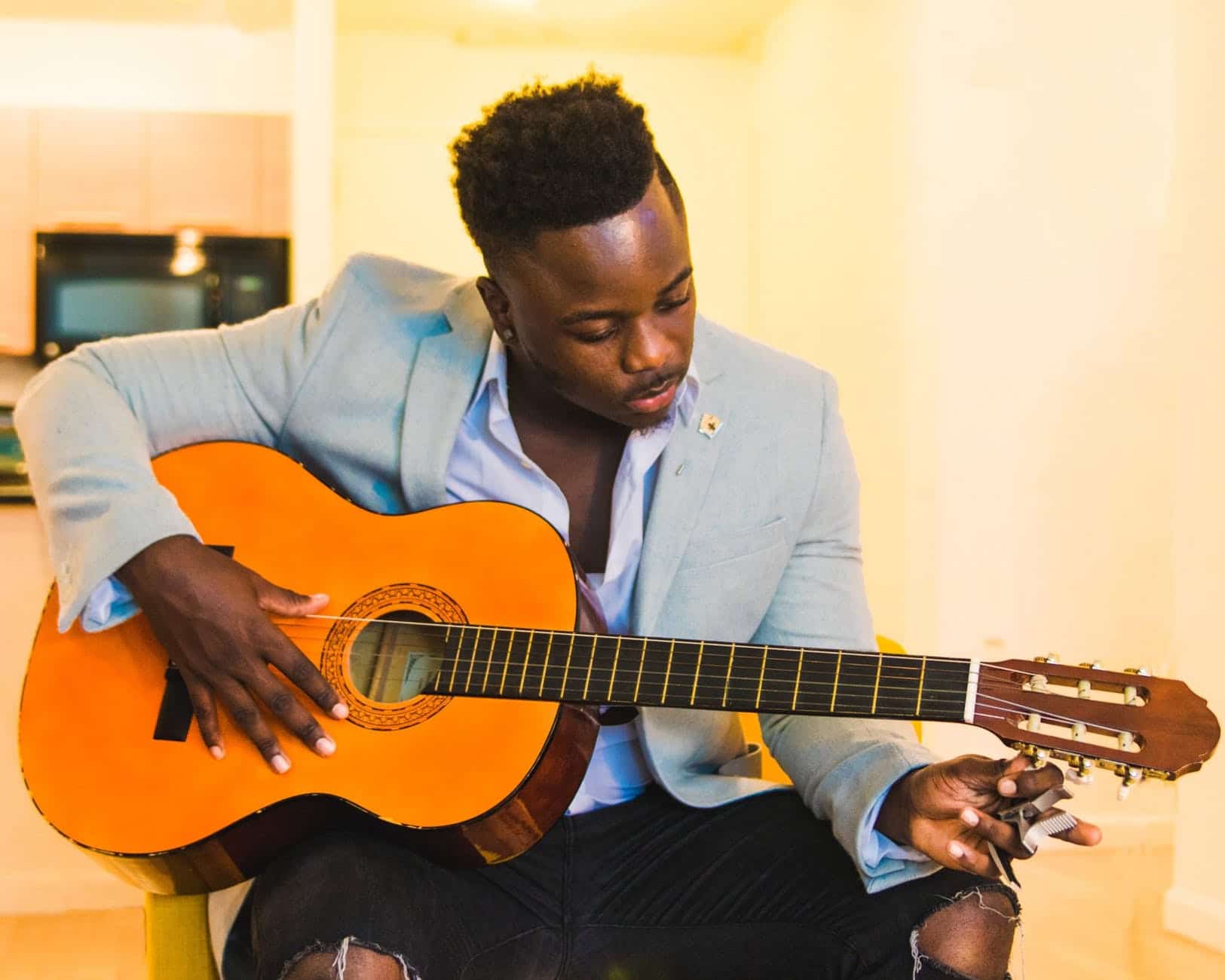 man tuning up his guitar