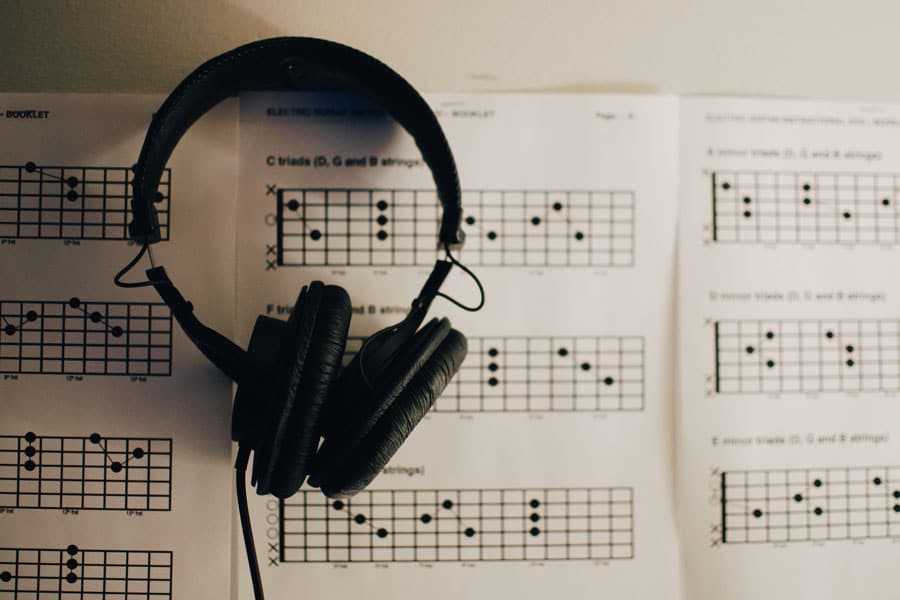 headphone on top a paper with guitar chords